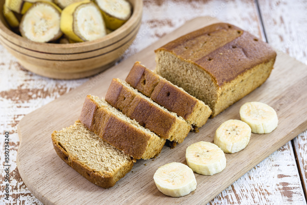 vegan banana bread, with banana slices on the side, on a white table. Healthy vegan life concept. vegan banana bread, with banana slices on the side, on a white table. Healthy vegan life concept.