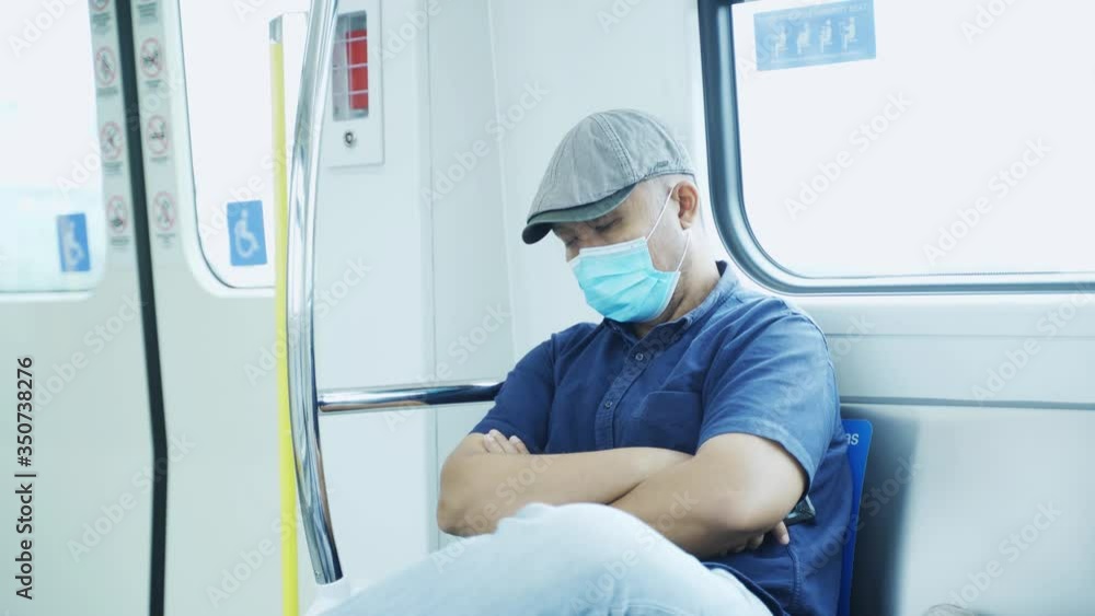Asian man wearing a mask and sleeping in train Asian man wearing a mask and sleeping in train
