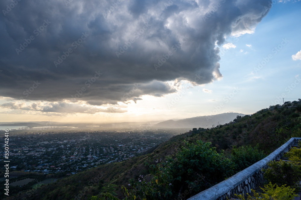 dark storm clouds roll and loom over a city during a cool sunset one spring afternoon dark storm clouds roll and loom over a city during a cool sunset one spring afternoon