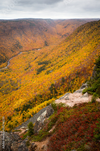 French Mountain valley in Cape Breton Nova Scotia during Autumn. Fall foliage of the mountains with multi colored deciduous trees, Cabot Trail 