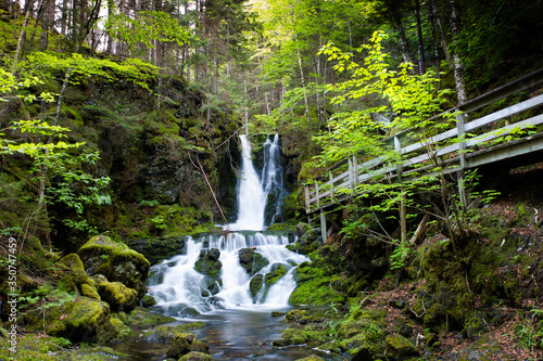 Pristine waterfalls with dense green natural forest trees in the middle of Fundy National Park. Dickson Falls, New Brunswick, Canada 