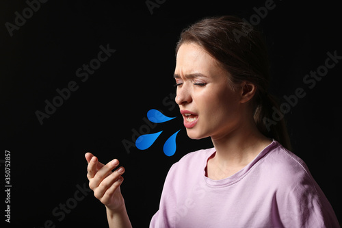 Coughing young woman on dar...
