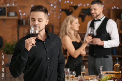 Young man enjoying red wine...