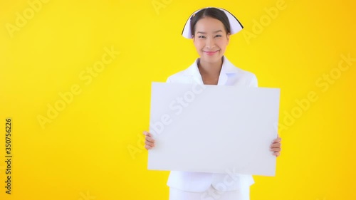 Asian smiling  nurse holding a blank sheet of the paper poster banner in hands with a happy face expression photo