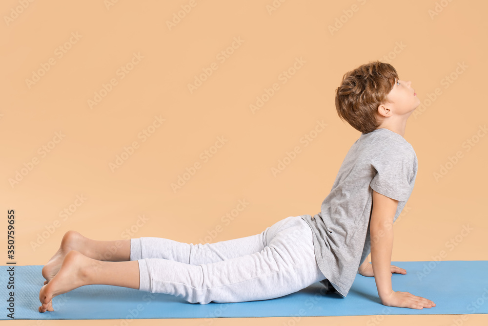 Cute little boy practicing yoga on color background Cute little boy practicing yoga on color background