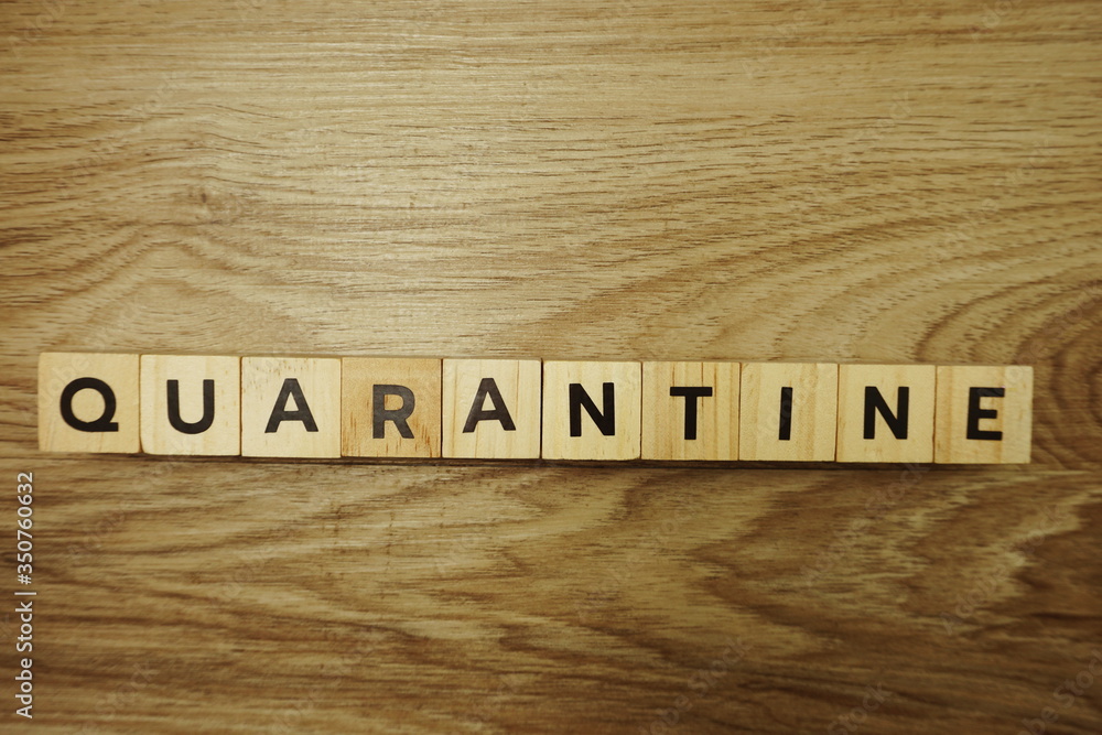 Quarantine alphabet letter on wooden background