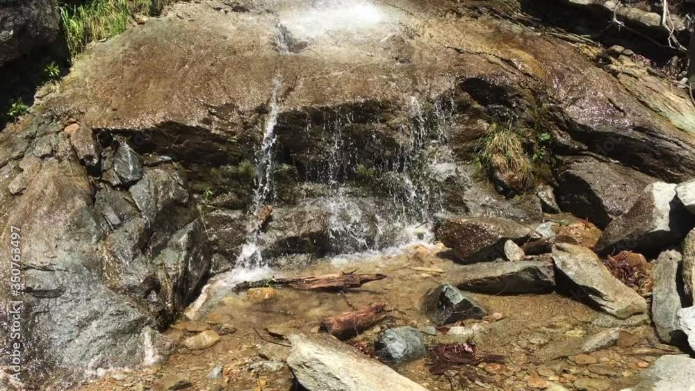 Fresh white water cascades down on flat granite rock into clear pools, static slow motion Fresh white water cascades down on flat granite rock into clear pools, static slow motion
