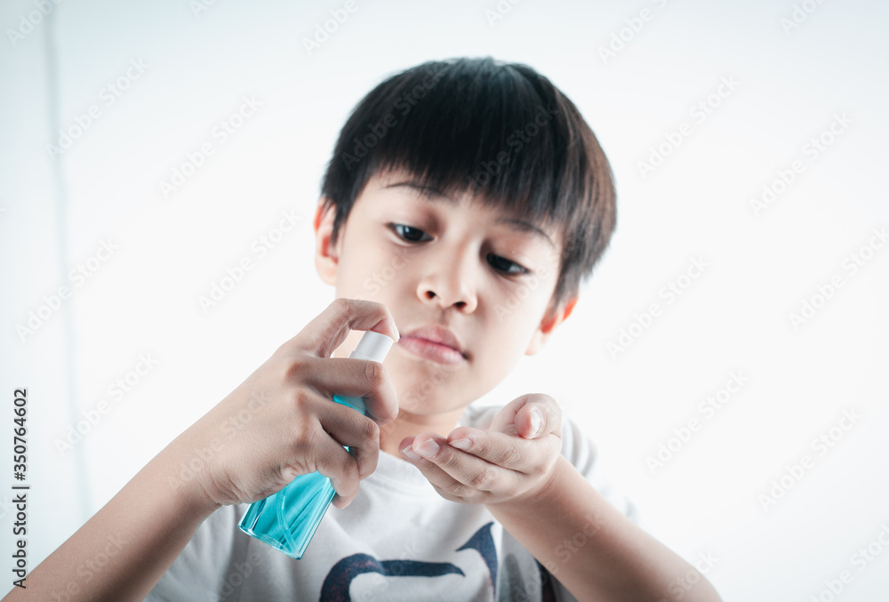 Asian boy holding a bottle of alcohol spray to clean the hands of covic19 Asian boy holding a bottle of alcohol spray to clean the hands of covic19