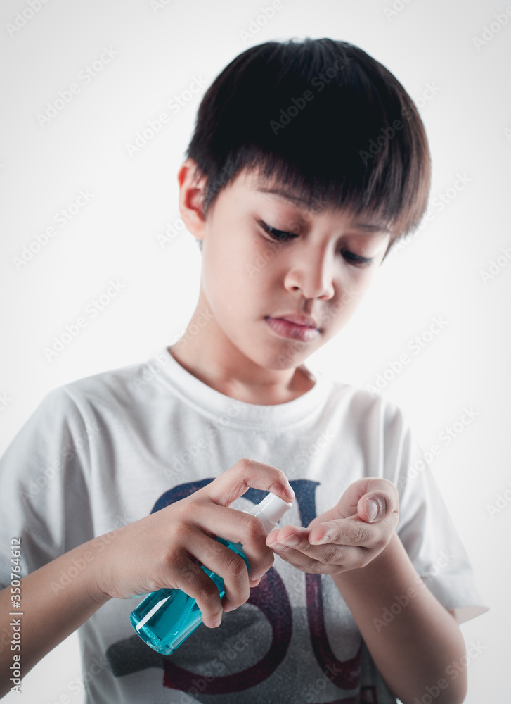 Asian boy holding a bottle of alcohol spray to clean the hands of covic19 Asian boy holding a bottle of alcohol spray to clean the hands of covic19