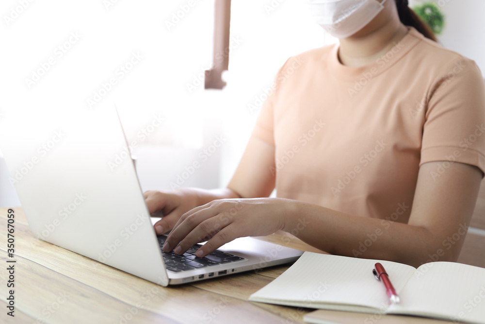 Fototapeta premium Woman working from home. wearing protective mask. COVID-19 Pandemic Coronavirus home isolation auto quarantine wearing face mask protective for spreading of disease virus 