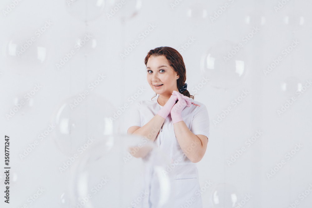 The doctor in rubber gloves. A girl wears a protective gear during an epidemic. Ads for antiseptics and medical equipment on a white background. Free medical care. Volunteers in the hospital The doctor in rubber gloves. A girl wears a protective gear during an epidemic. Ads for antiseptics and medical equipment on a white background. Free medical care. Volunteers in the hospital