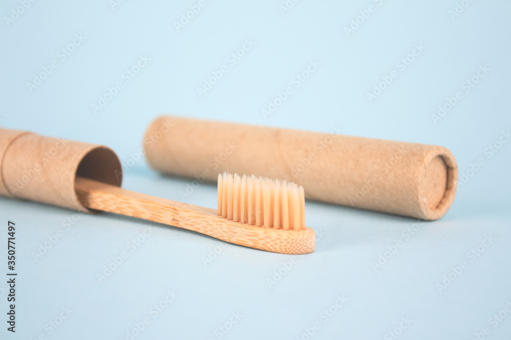 Close up of natural bamboo toothbrushe packed in reusable paper tube on blue background with copy space. Sustainable lifestyle and plastic free concept, bathroom essentials in zero waste home, mockup Close up of natural bamboo toothbrushe packed in reusable paper tube on blue background with copy space. Sustainable lifestyle and plastic free concept, bathroom essentials in zero waste home, mockup