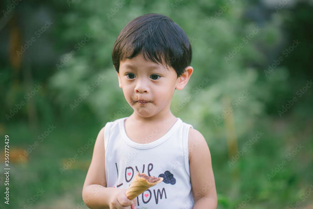 Asia boy he mouth aftertaste from eating chocolate ice cream or chocolate dessert. A sweet-toothed child eat chocolate. Kid with dirty face eating ice cream. Cute toddler boy eating icecream. Asia boy he mouth aftertaste from eating chocolate ice cream or chocolate dessert. A sweet-toothed child eat chocolate. Kid with dirty face eating ice cream. Cute toddler boy eating icecream.