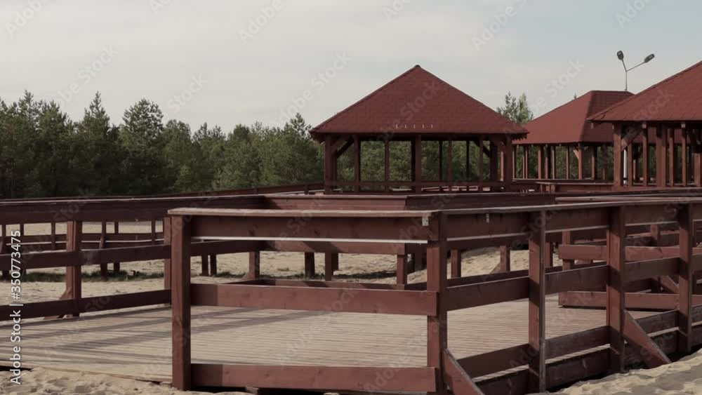 Outdoor wooden bower. Gazebo. shelter facilities on The Bledowska Desert sands surrounded by trees and white sands at sunny day. pan shot. no people. 24fps. Outdoor wooden bower. Gazebo. shelter facilities on The Bledowska Desert sands surrounded by trees and white sands at sunny day. pan shot. no people. 24fps.