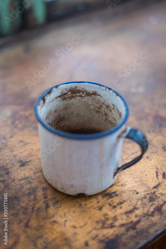 Old Enamel Mug on a worn wooden table