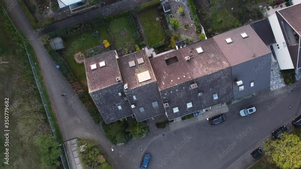 Top down Drone view over family homes in central Europe while drone is flying into the setting sun Top down Drone view over family homes in central Europe while drone is flying into the setting sun