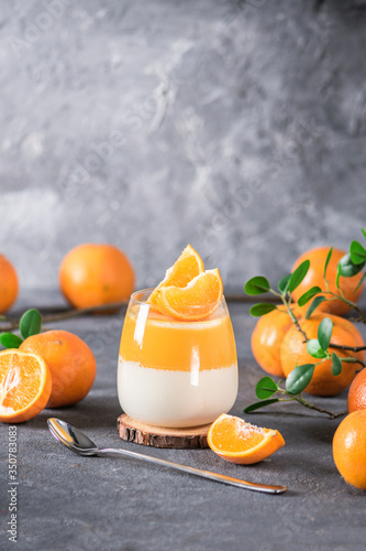 Panna cotta dessert with fresh oranges on dark background