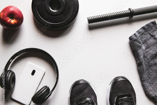 Towel, sneakers, and smartphone with headphones on a white background