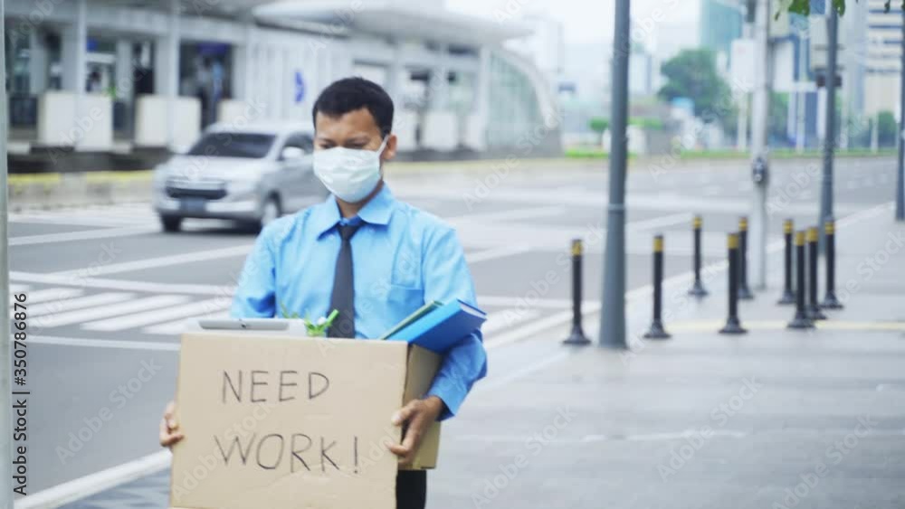 Male employee holding box and text of need work Male employee holding box and text of need work