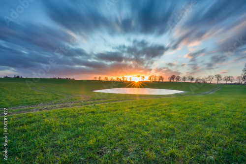 Spring fields with a picturesque lake at sunset Poland