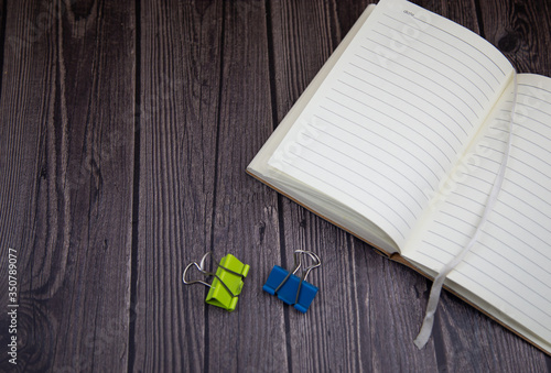 open notebook on a dark background, white pages, wooden background