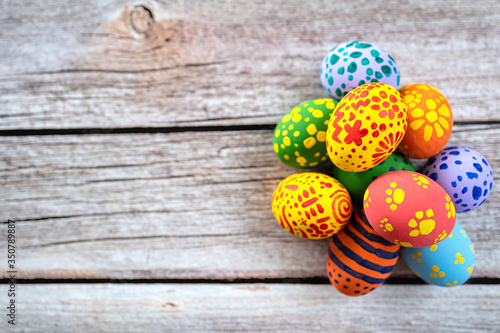 Pile of painted ester eggs in various colors on wooden table. Ester holiday concept.