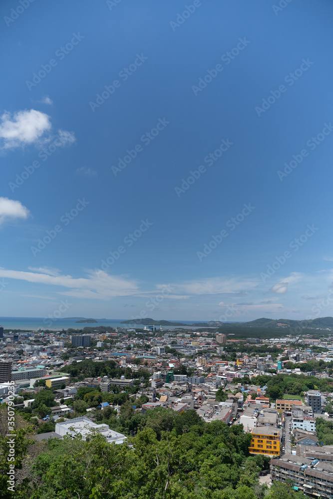 panoramic scene at Khao Rung Phuket viewpoint hilltop, home , building and green  tree. Sea and mountain long distance, beautiful cloudy blue sky background at day time, nature and travel concept..