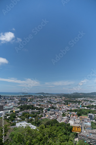 panoramic scene at Khao Rung Phuket viewpoint hilltop, home , building and green tree. Sea and mountain long distance, beautiful cloudy blue sky background at day time, nature and travel concept..