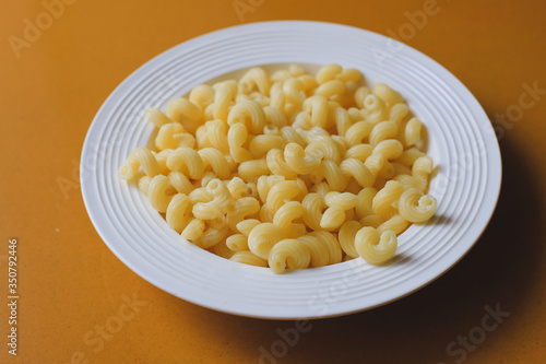 short pasta on a white plate with butter.