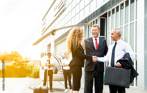 Business team shaking hand to appreciate each other about aviation business and helicopter platform background, Man and woman hands shake with partnership successful outdoors, Deal