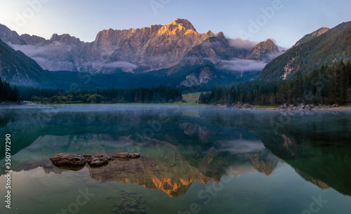 Spectacular, beautiful sunrise over the alpine Lake Laghi di Fusine in the Julian Alps in Italy
