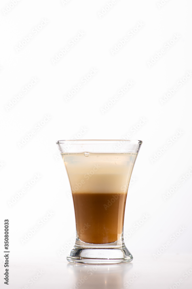 B52 coffee creamy alcohol cocktail in three layers in a shot glass on a black background B52 coffee creamy alcohol cocktail in three layers in a shot glass on a black background