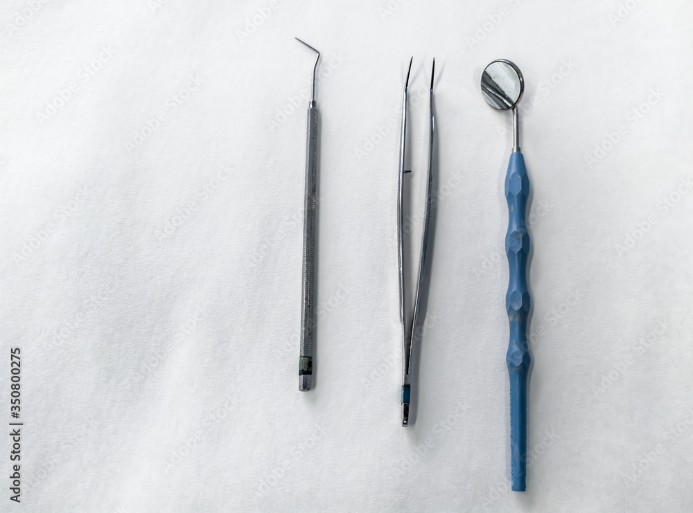 Dental instruments: mouth mirror, periodontal probe, college tweezers Dental instruments: mouth mirror, periodontal probe, college tweezers