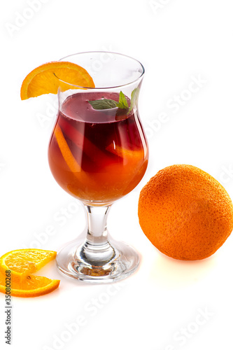 sangria or mulled wine cocktail in a glass with oranges, wine and juice on a white background