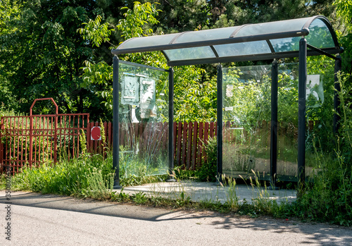 Fotografie Old abandoned bus stop with broken glass, on the side of the road