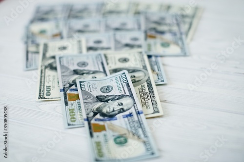 A stack of money. Heap of one hundred dollar bills on money background. Fake money. Shallow depth of field. Selective focus. photo