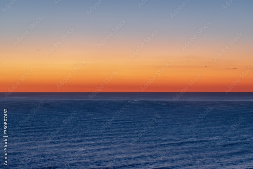 Aerial view of bright sunset sky over Tasman sea horizon