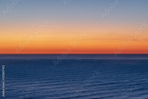 Aerial view of bright sunset sky over Tasman sea horizon