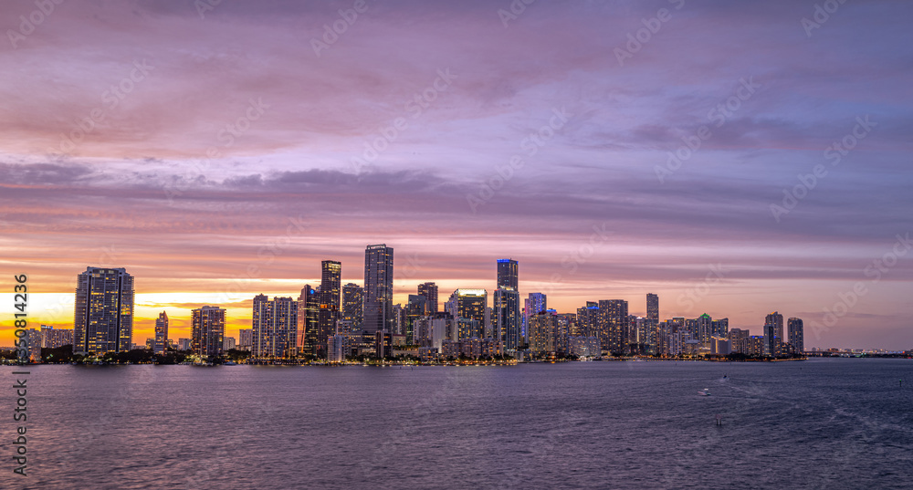 Miami city skyline panorama with urban skyscrapers over sea with reflection. Skyscrapers and harbor.