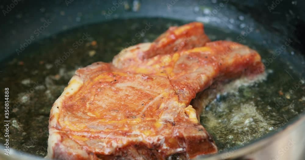 Large steak meat fried in boiling oil close up Large steak meat fried in boiling oil close up