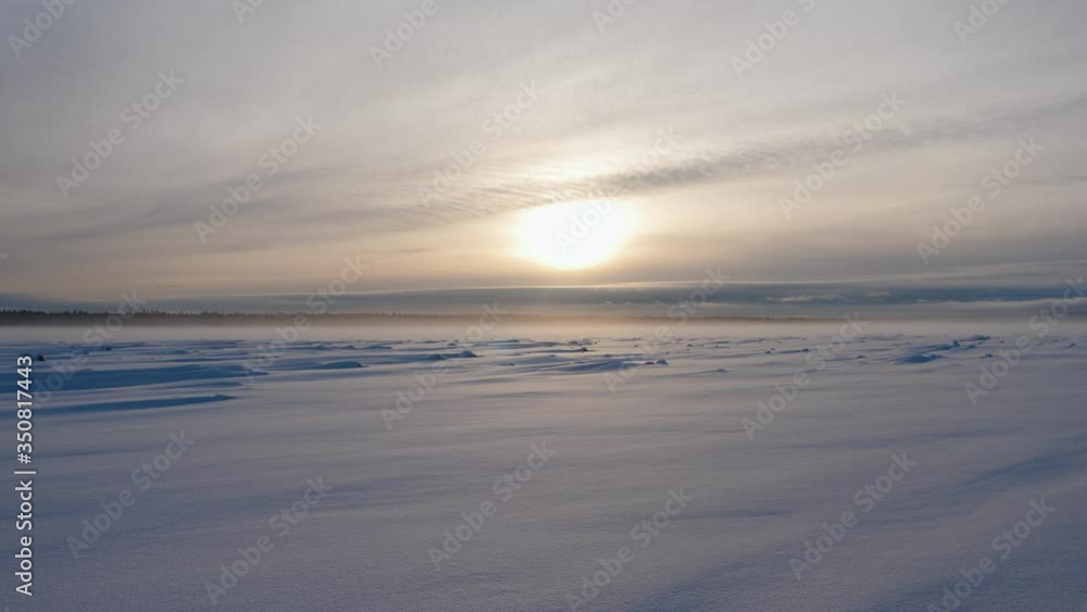 Stunning sunrise over the frozen Yenisei river in Siberia. The large yellow sun rising over the winter forest. 4K Stunning sunrise over the frozen Yenisei river in Siberia. The large yellow sun rising over the winter forest. 4K