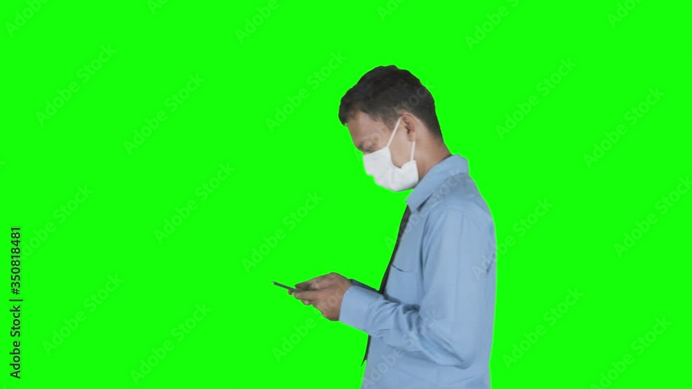 Side view of businessman with cellphone and mask Side view of businessman with cellphone and mask