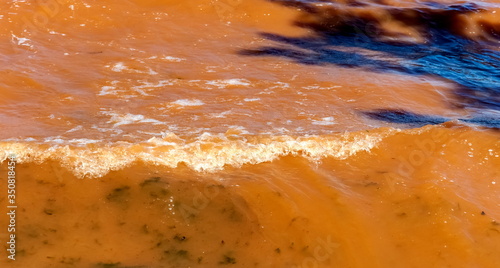 Waves on the surface of the river, red from dissolved clay (Background, banner, Wallpaper)
