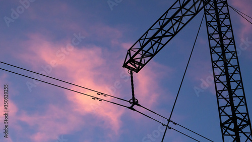 Silhouette of high voltage electric tower at beautiful sunset with dramatic clouds