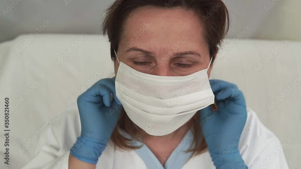 female doctor putting on protective mask at clinic female doctor putting on protective mask at clinic