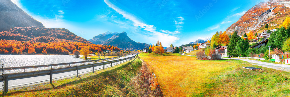 Awesome autumn scene in Maloja village and asphalt road on the shore of Sils lake(Silsersee)