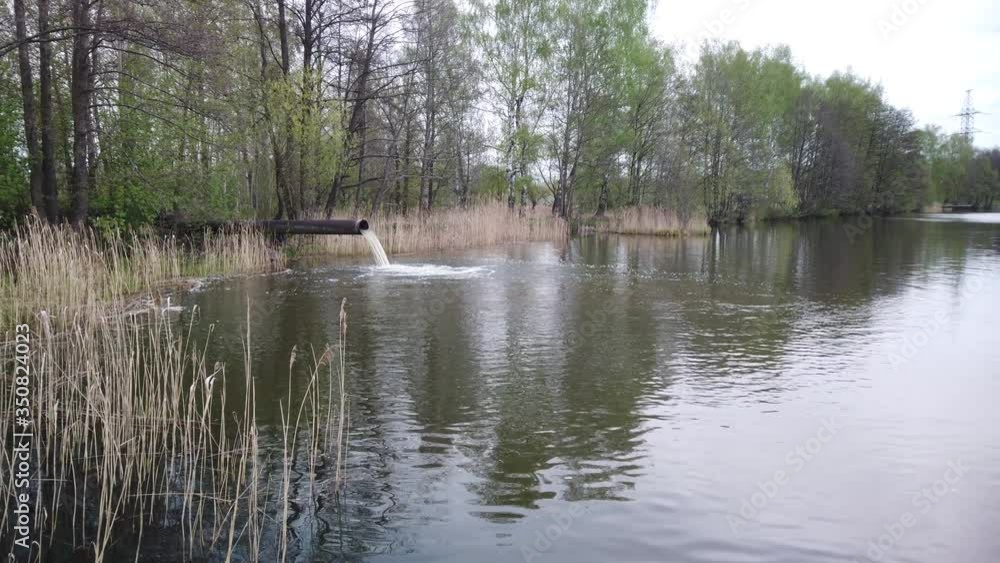 Waste emissions into water, water pollution. A large pipe from the plant pollutes the ecology of the river. Waste emissions into water, water pollution. A large pipe from the plant pollutes the ecology of the river.