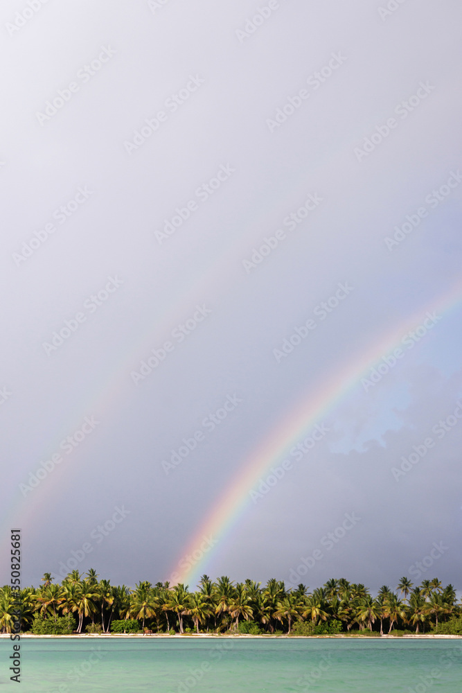 Tropical rainbow over palm trees on the island of Saona. Caribbean Sea Turquoise Tropical rainbow over palm trees on the island of Saona. Caribbean Sea Turquoise