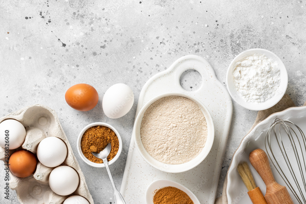 Ingredients for baking on a culinary background. Eggs, flour, cinnamon, sugar, soda on the kitchen table. Concept of preparation for baking. Top view with space for text Ingredients for baking on a culinary background. Eggs, flour, cinnamon, sugar, soda on the kitchen table. Concept of preparation for baking. Top view with space for text