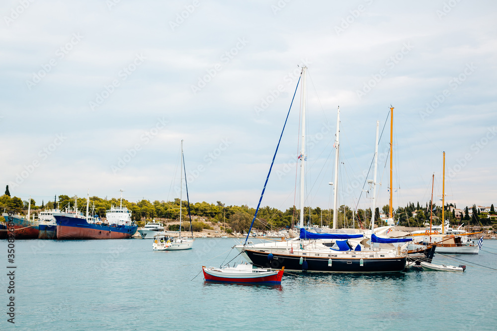 many yachts in the anchored bay, yachts are in the marina near the pier, small and large yachts